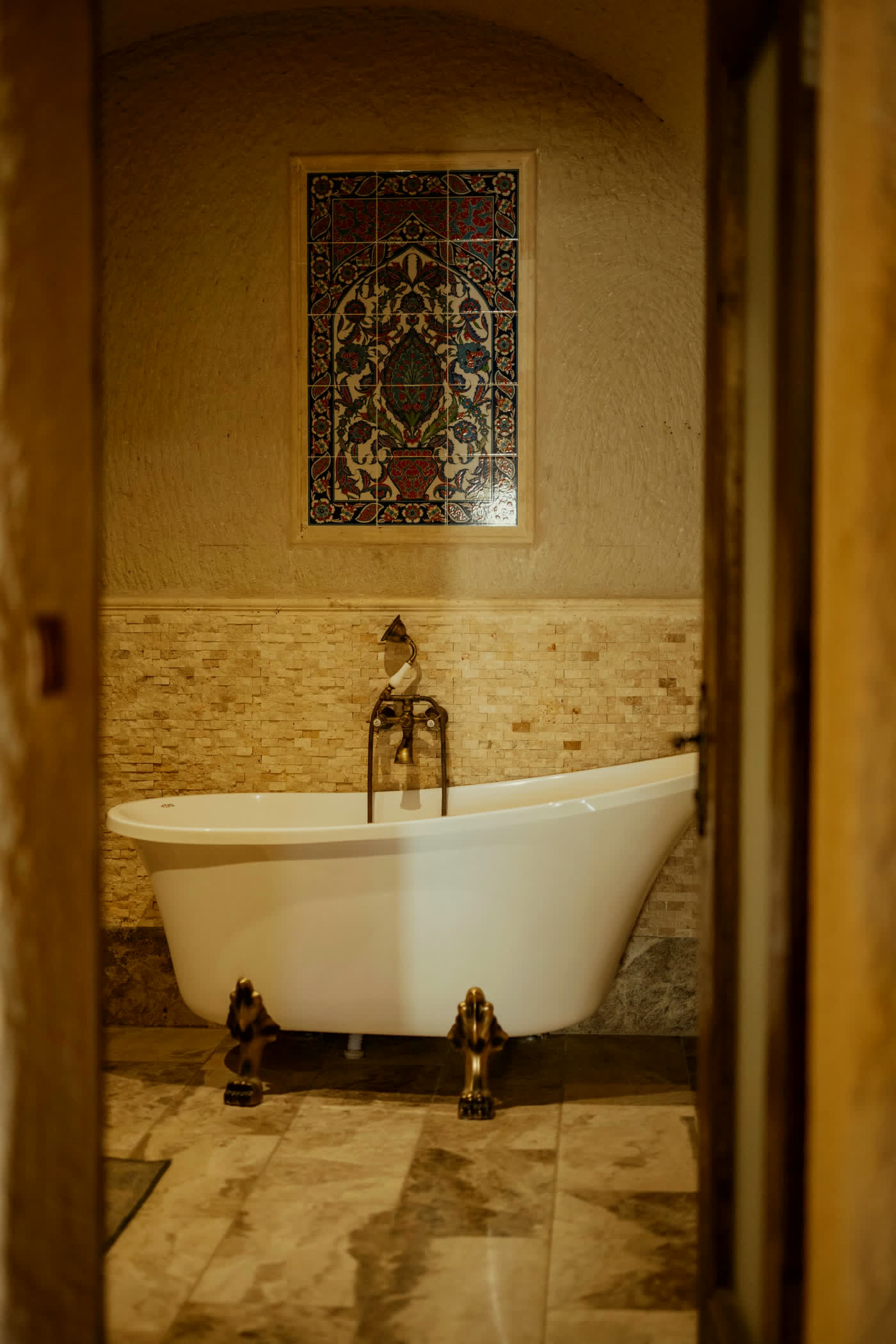 Freestanding bathtub in a warm tiled bathroom