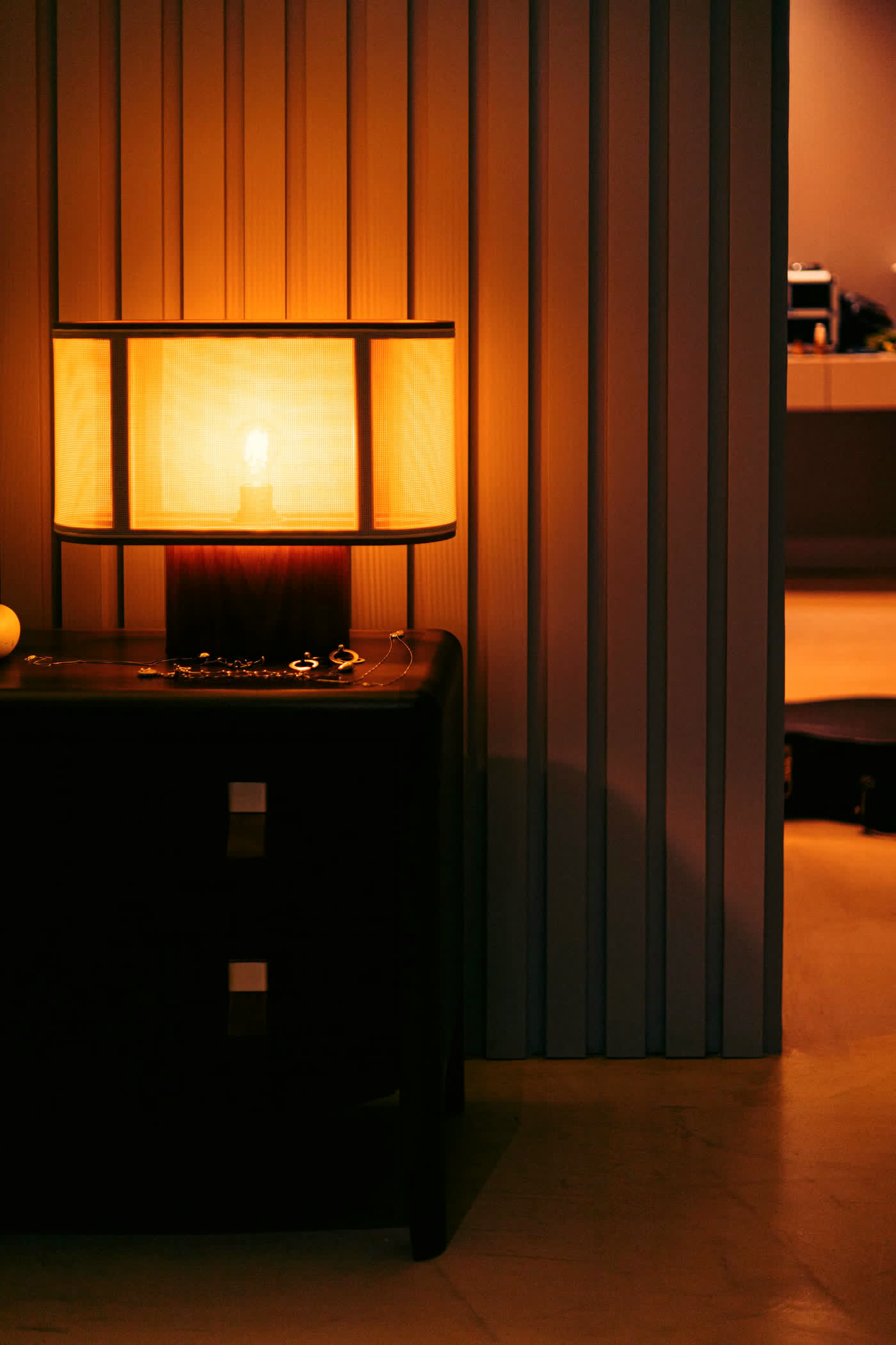 Warm bedside lamp on a dark timber nightstand
