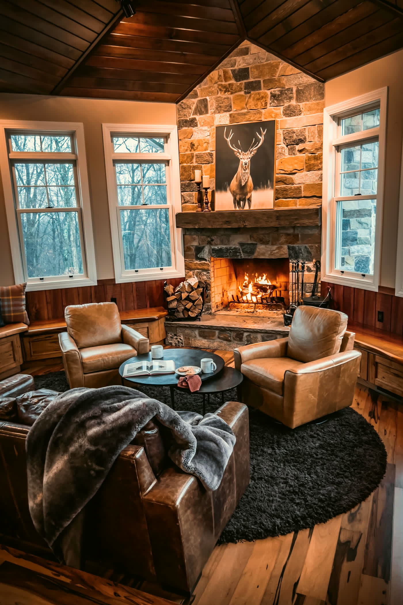 Lounge with a lit stone fireplace and leather armchairs