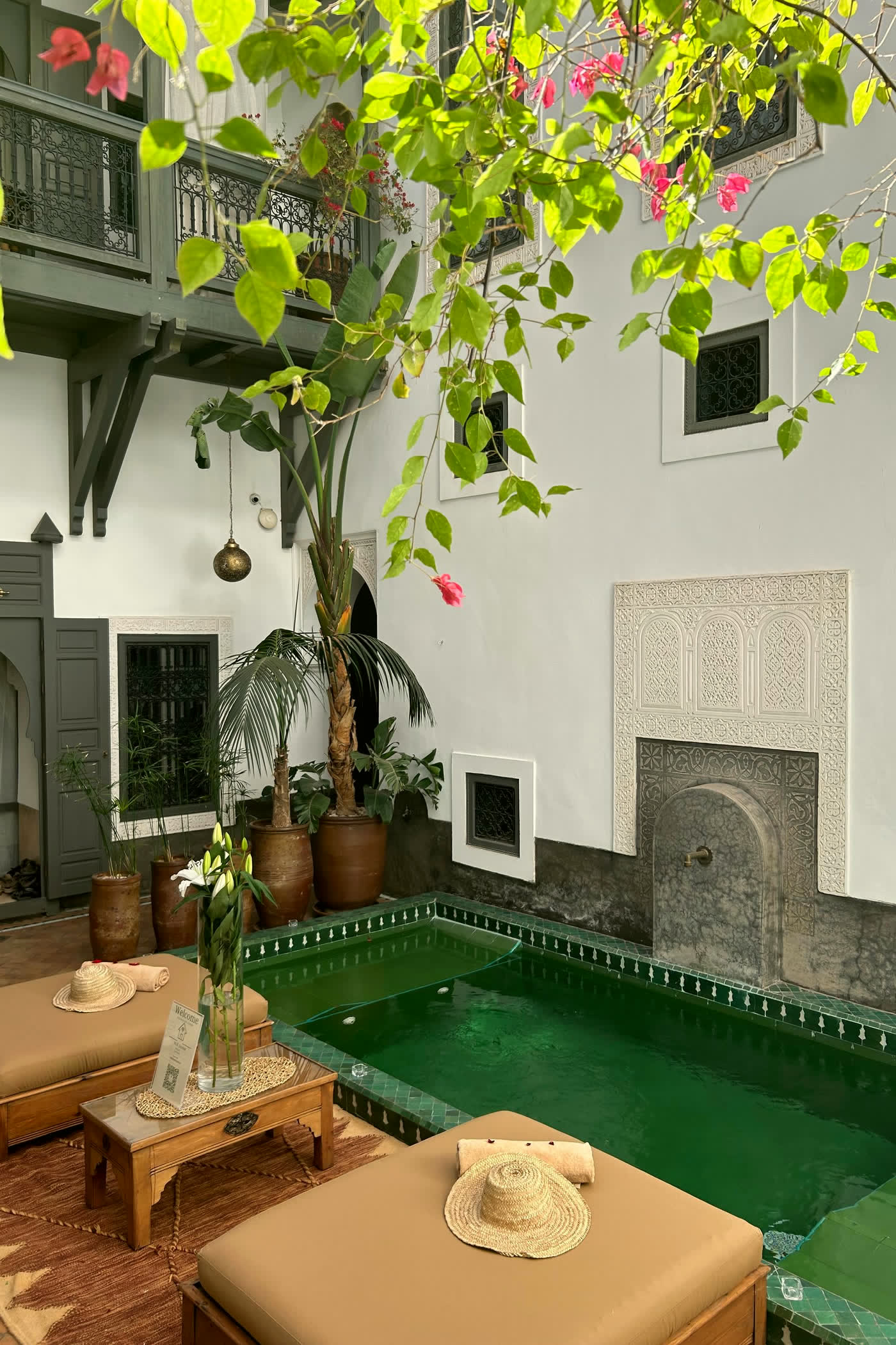 Riad courtyard with a green tiled plunge pool and climbing greenery