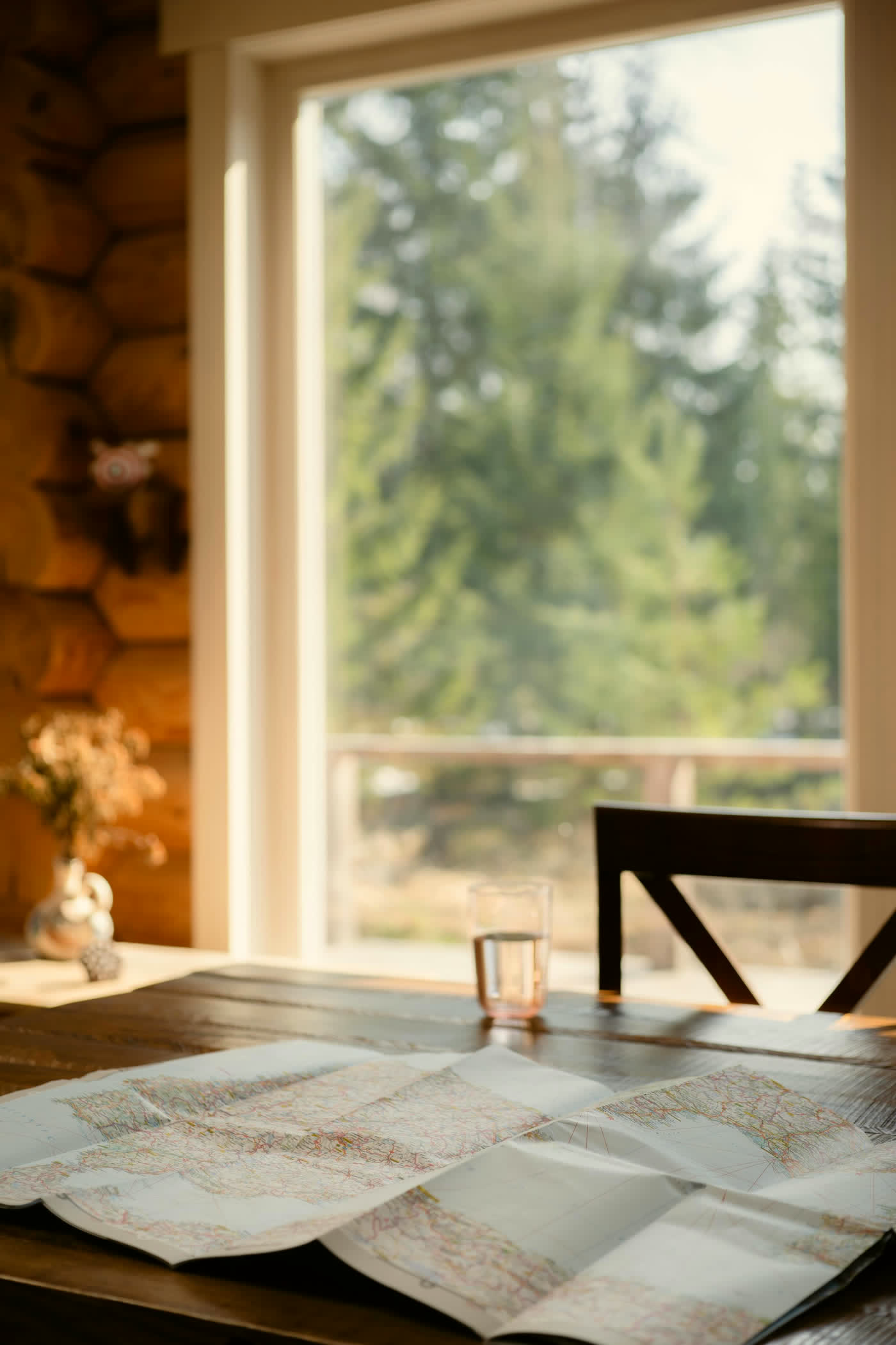 Map spread on a cabin table beside a sunlit window